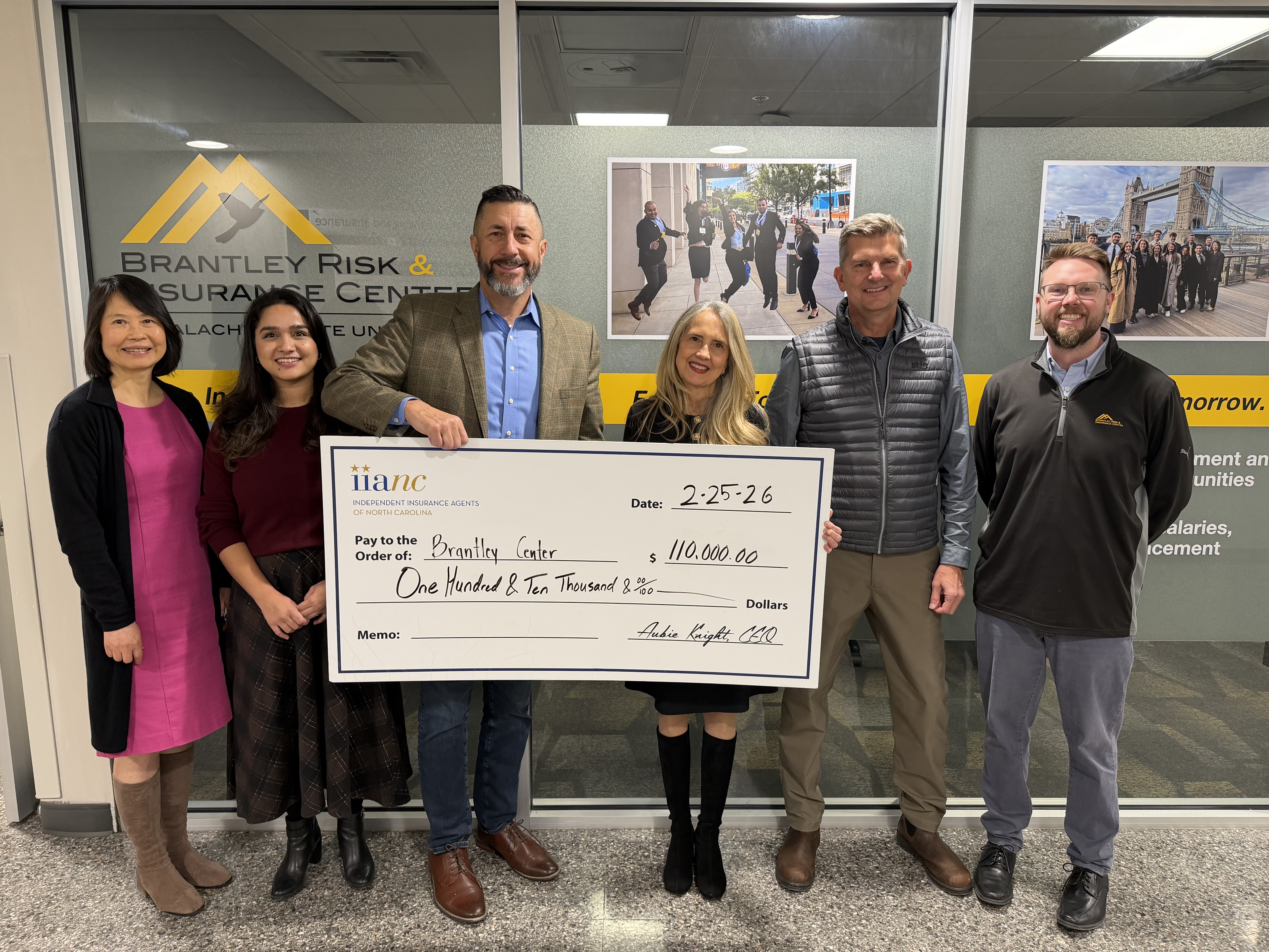 brantley center staff holding a check with a donation from Aubie Knight of the IIANC